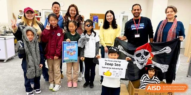 A group of students and staff members smile together while holding a poster and awards at Xi_an Hanova International School.