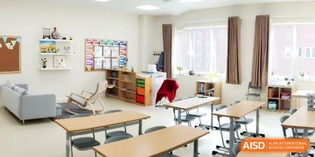 A spacious classroom area with wooden tables and storage units for student learning materials at Xi_an Hanova International School.