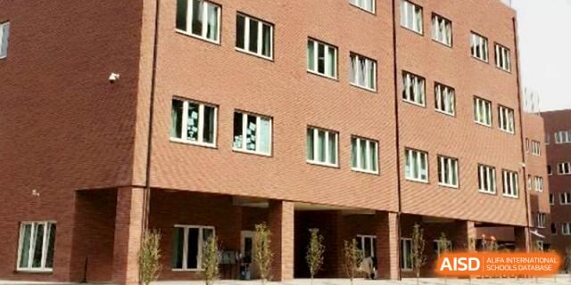 The exterior facade of a multi-story red brick school building under a clear blue sky at Xi_an Hanova International School.