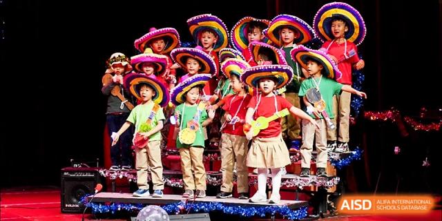 Students perform a vibrant cultural dance wearing colorful sombreros and outfits on a stage at Xi_an Hanova International School.