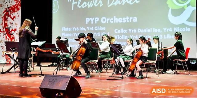 The student orchestra performs "Flower Dance" with cellos and violins during a school concert at Xi_an Hanova International School.