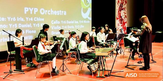 Student musicians play various instruments including the glockenspiel during an orchestra performance at Xi_an Hanova International School.