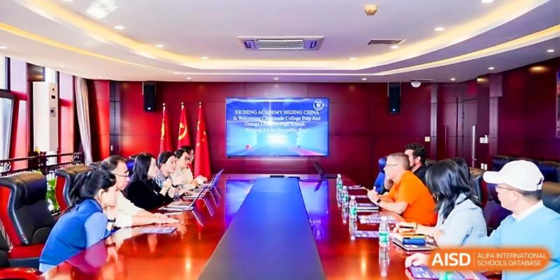 Staff members sit around a large conference table for a formal meeting in a boardroom at Beijing Xicheng Academy.
