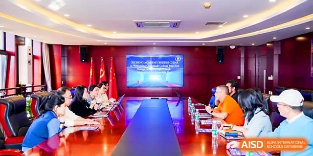 Staff members sit around a large conference table for a formal meeting in a boardroom at Beijing Xicheng Academy.