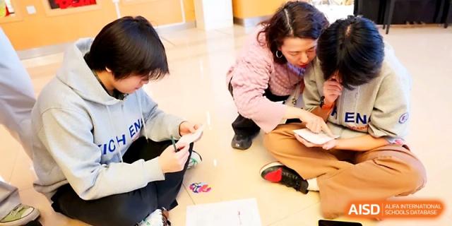 Students sit on the floor and interact during an informal and creative group learning activity at Beijing Xicheng Academy.