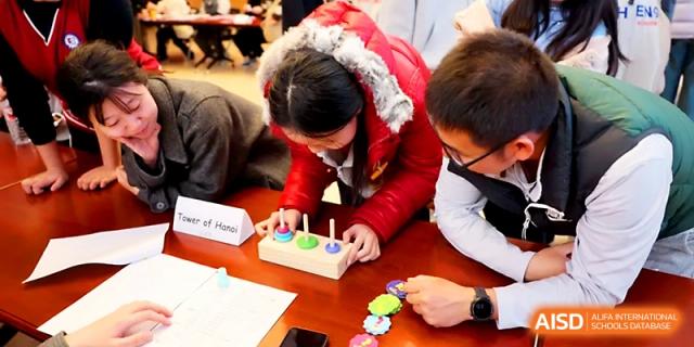 A student focuses on a wooden educational puzzle during a logic or science-based school activity at Beijing Xicheng Academy.