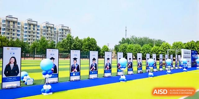 A row of vertical banners featuring student achievements stands along an outdoor path at Beijing Xicheng Academy.