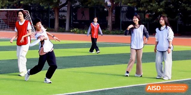 Students participate in various team-building games and athletic drills on the school's outdoor track at Beijing Xicheng Academy.