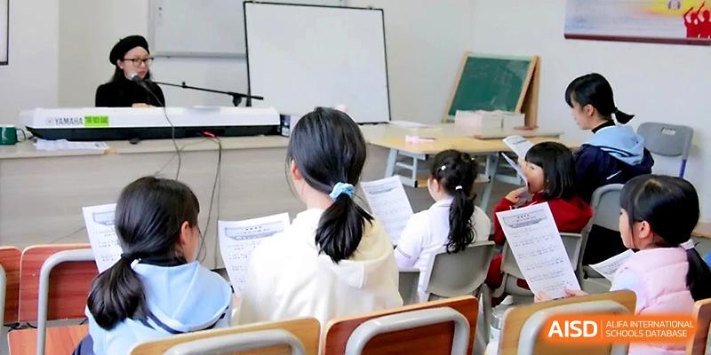 Students sit in a row at their desks, focusing on their papers while a teacher leads the session from the front of the room at Yangjiang Yangdong Eone school.