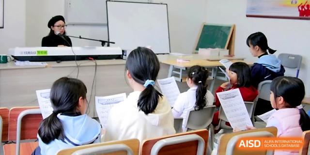 Students sit in a row at their desks, focusing on their papers while a teacher leads the session from the front of the room at Yangjiang Yangdong Eone school.