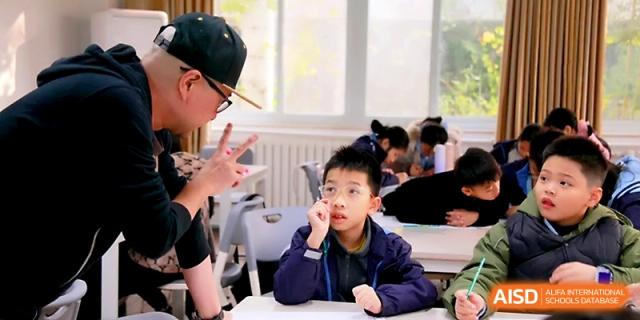 A teacher wears a cap while giving personalized instructions to a student during a lesson at Yangjiang Yangdong Eone school.