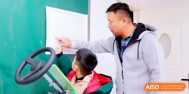 An instructor points to a whiteboard while guiding a young student through a learning exercise at Yangjiang Yangdong Eone school.