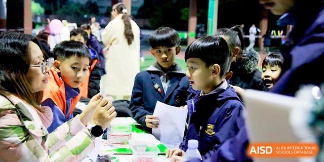 Students engage in a group activity, discussing their work together around a classroom table at Yangjiang Yangdong Eone school.