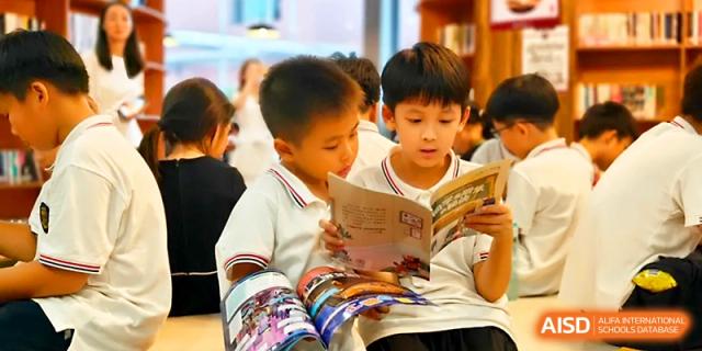 Two young boys sit together and enjoy reading a colorful picture book in the school library at Yangjiang Yangdong Eone school.