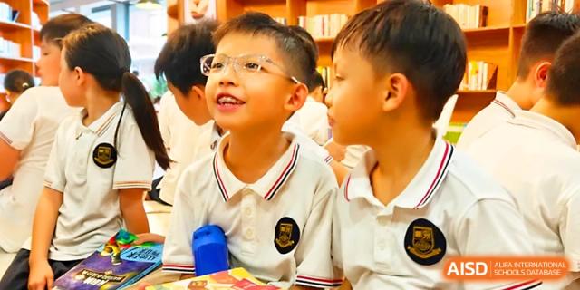 Two boys in white school polos share a happy moment while learning together in the classroom at Yangjiang Yangdong Eone school.