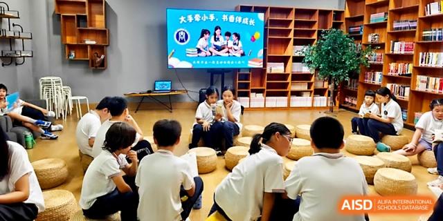 A group of students sits on floor poufs during a presentation in a well-equipped media room at Yangjiang Yangdong Eone school.