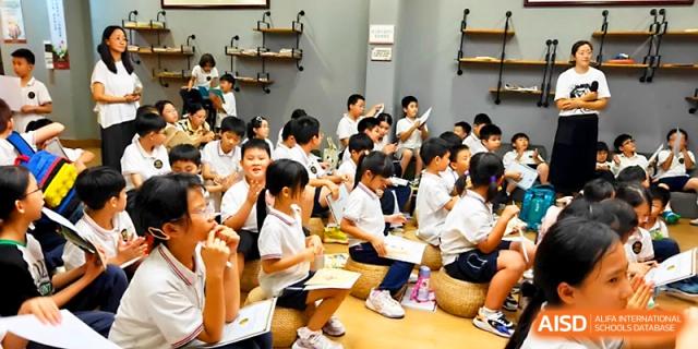 Children sit attentively on stools during an interactive group storytime session in class at Yangjiang Yangdong Eone school.