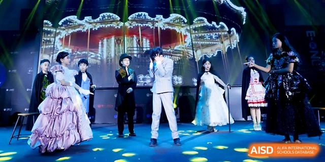 A young actor in a white suit performs a dramatic scene under bright blue spotlighting during a play at Yangjiang Yangdong Eone school.