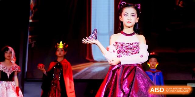 A student in a shimmering pink gown performs a graceful solo during a dramatic stage performance at Yangjiang Yangdong Eone school.