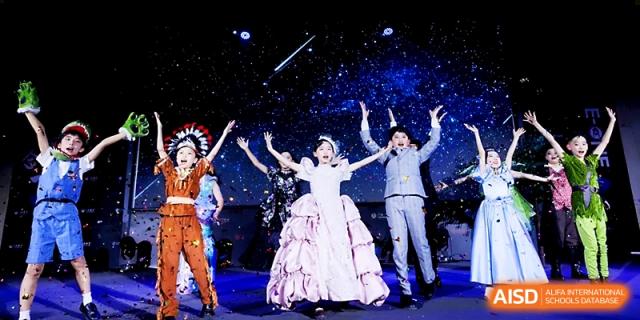 A group of students in elaborate costumes take a final bow under a starry stage backdrop after a show at Yangjiang Yangdong Eone school.