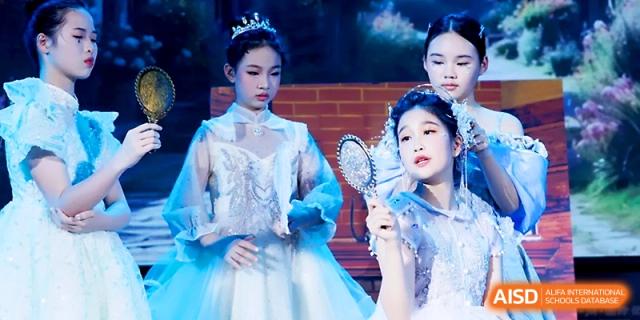 Students dressed as princesses look into hand mirrors during a magical fairy-tale themed stage production at Yangjiang Yangdong Eone school.