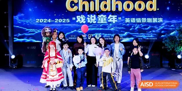 A large group of students and teachers pose together on stage after a successful "Childhood" themed performance at Yangjiang Yangdong Eone school.