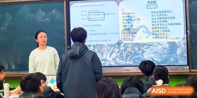 A student stands to answer a question in front of a digital screen during a collaborative classroom lesson at Yangzhou Shuren High School.