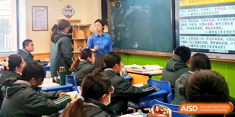 A teacher leads a discussion from the front of the classroom while students listen and take notes at Yangzhou Shuren High School.
