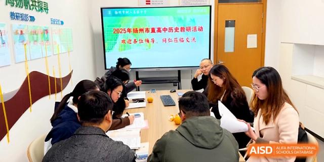 Staff members gather around a large conference table for a professional development meeting and presentation at Yangzhou Shuren High School.