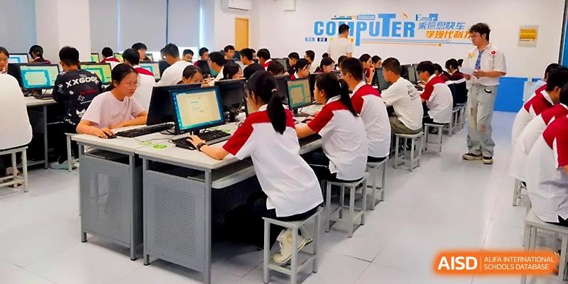 Students in red and white uniforms sit at individual computer stations during a technology and informatics class at Yangzhou Shuren High School.