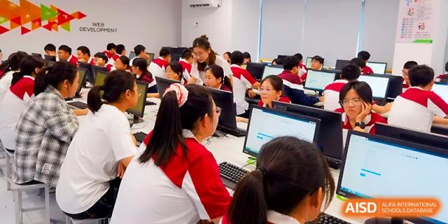 Rows of students focus on their monitors while participating in a computer-based lesson in a clean, modern lab at Yangzhou Shuren High School.