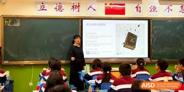 A teacher stands by a digital whiteboard presenting educational materials to a class of attentive students at Yangzhou Shuren High School.