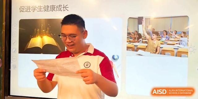 A smiling student stands at the front of the room and shares his work with the class during an interactive lesson at Yangzhou Shuren High School.