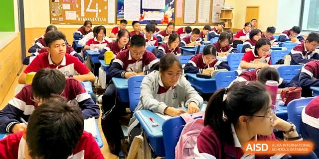 A classroom full of students in uniforms focus on their written assignments during a quiet independent study period at Yangzhou Shuren High School.