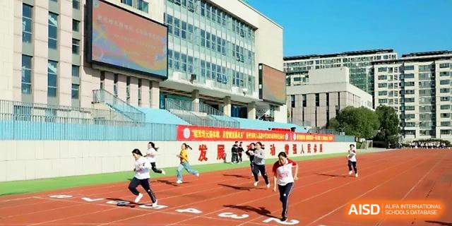 Students sprint toward the finish line on the red running track during a competitive racing event at Yangzhou Shuren High School.