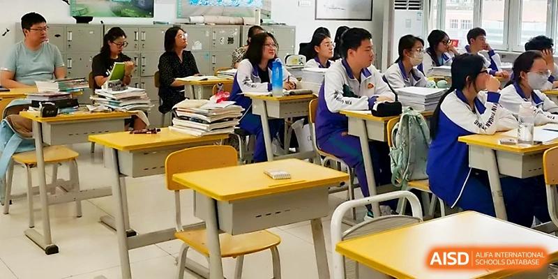 Rows of students sit attentively at their desks, listening to a teacher during a structured academic session at Yinchuan No.1 High School.