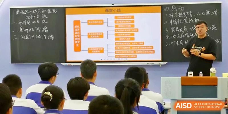 A classroom of students observes a large digital screen showing an orange and white educational diagram at Yinchuan No.1 High School.