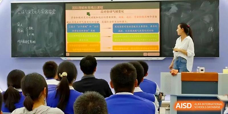 Students look toward a large screen displaying a colorful flowchart during a detailed classroom presentation at Yinchuan No.1 High School.