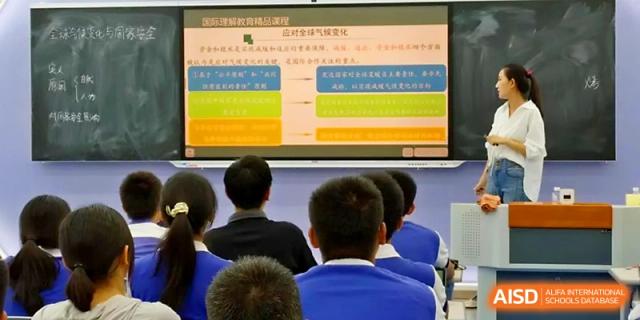 Students look toward a large screen displaying a colorful flowchart during a detailed classroom presentation at Yinchuan No.1 High School.
