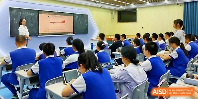 Students use individual laptops and tablets to follow along with a digital lecture in a modern classroom at Yinchuan No.1 High School.