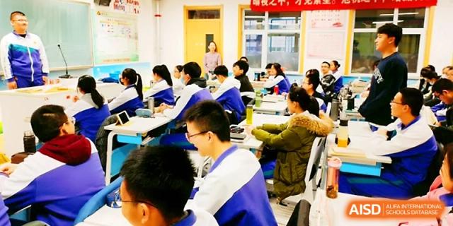 A classroom full of students in blue and white jackets listens intently to a lecture during a morning session at Yinchuan No.1 High School.