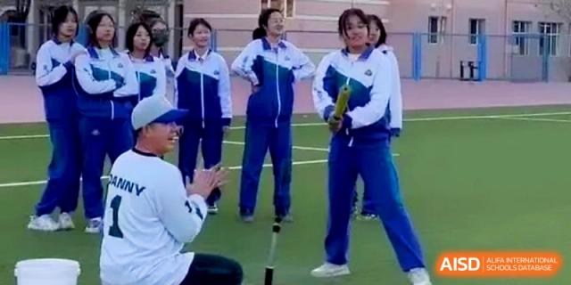 Students in matching athletic gear participate in a group training session on the expansive outdoor sports field at Yinchuan No.1 High School.