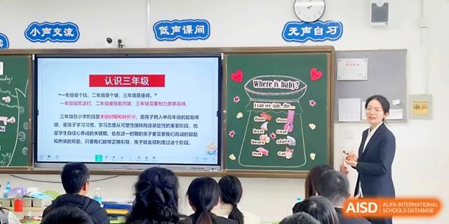 A presentation on a large digital screen provides information to parents during a school event at Zhangjiagang IVY Experimental School.
