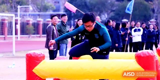 A student focuses on an obstacle course challenge during a spirited outdoor sports day at Zhangjiagang IVY Experimental School.