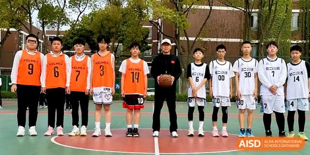 A basketball team in orange and white jerseys poses for a group photo with their coach at Zhangjiagang IVY Experimental School.