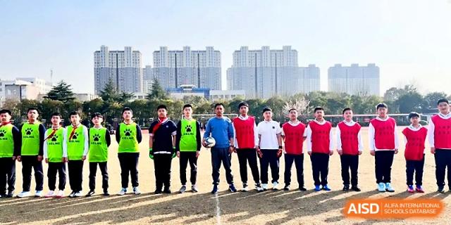 A group of male students in matching athletic wear poses together outdoors on a sunny day at Zhangjiagang IVY Experimental School.