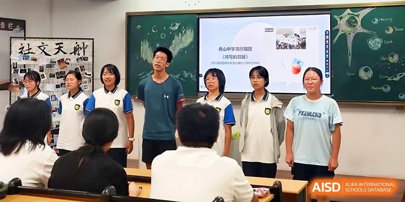 A group of students stands at the front of the classroom to deliver a presentation to their peers at Zhejiang ZhouShan High School.