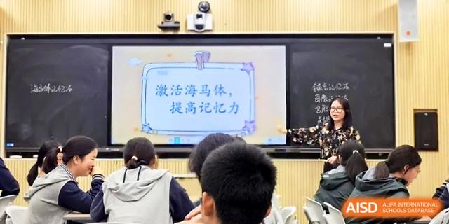 A screen displays a lesson about memory and the hippocampus to a focused group of attentive students at Zhejiang ZhouShan High School.