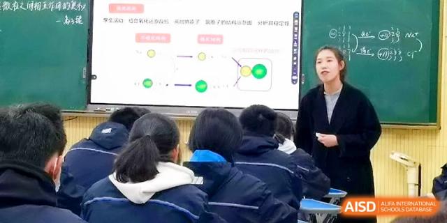 A female instructor explains a flow chart on a digital screen to a class of engaged high school students at Zhejiang ZhouShan High School.