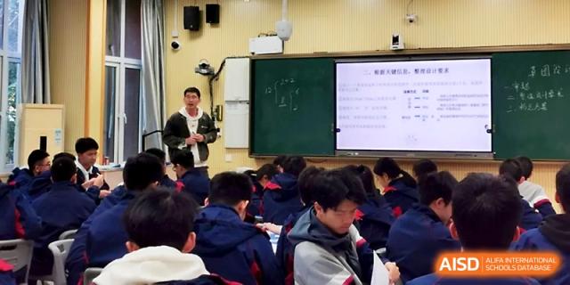 A teacher stands by a chalkboard while students in blue jackets take notes during a focused morning class at Zhejiang ZhouShan High School.